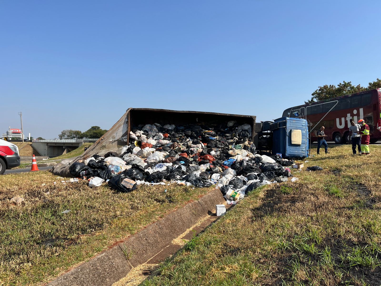 Caminhão carregado com carga de lixo tomba em alça de acesso à SP-101, em Campinas 